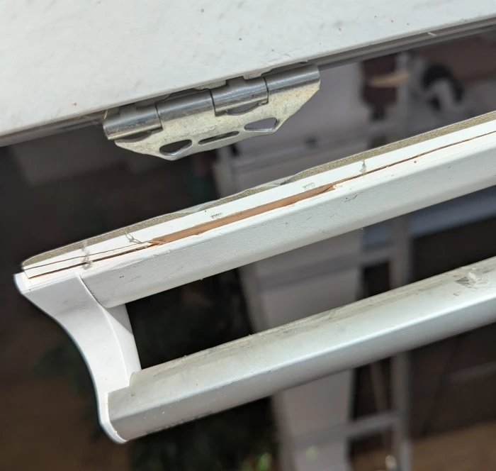 Wooden Velux window handle uncoupled from the window frame on one side